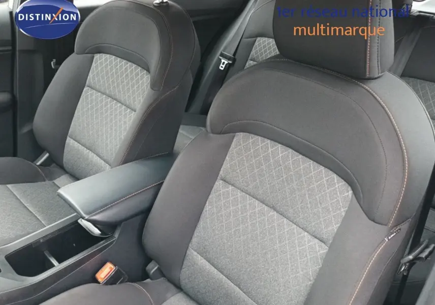 Gros plan sur les sièges avant gris à surpiqûres orange et accoudoir central du MG3 Hybrid+ 2024.