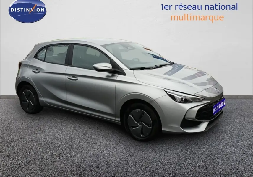 Vue 3/4 avant droite d'une MG3 Hybrid+ gris métallisé avec jantes en acier et enjoliveurs noirs, stationnée sur sol gris.