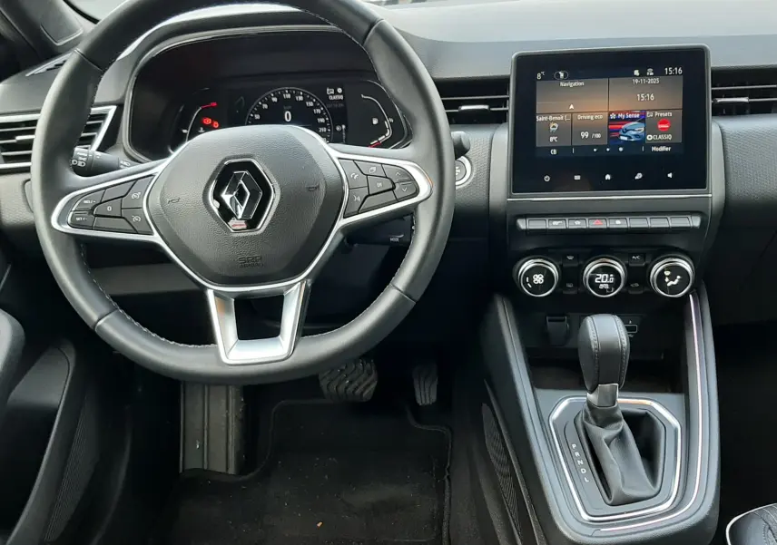 Vue intérieure du poste de conduite de la Renault Clio V TCE 90 Intens, tableau de bord moderne avec écran tactile et volant multifonction.