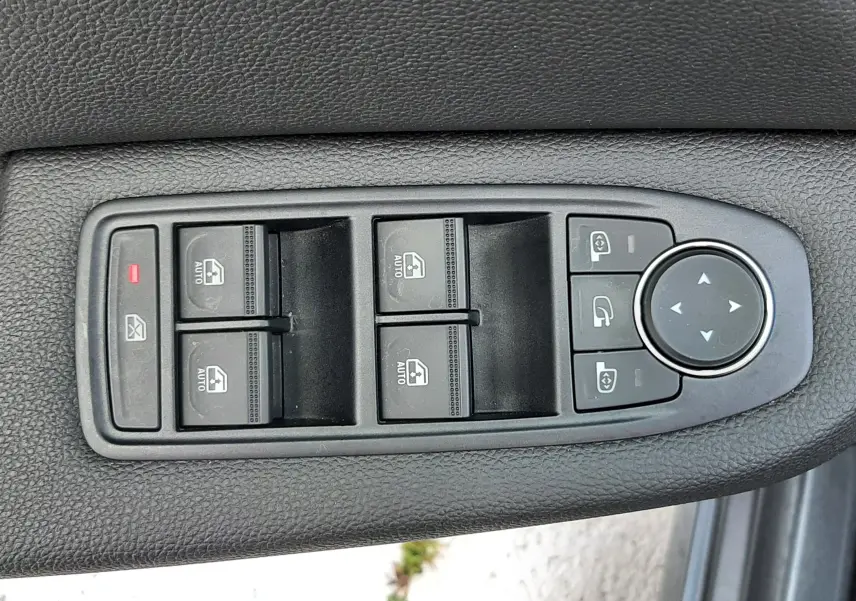Panneau de commandes des vitres et rétroviseurs sur porte côté gauche d'une Renault Clio V gris titanium.