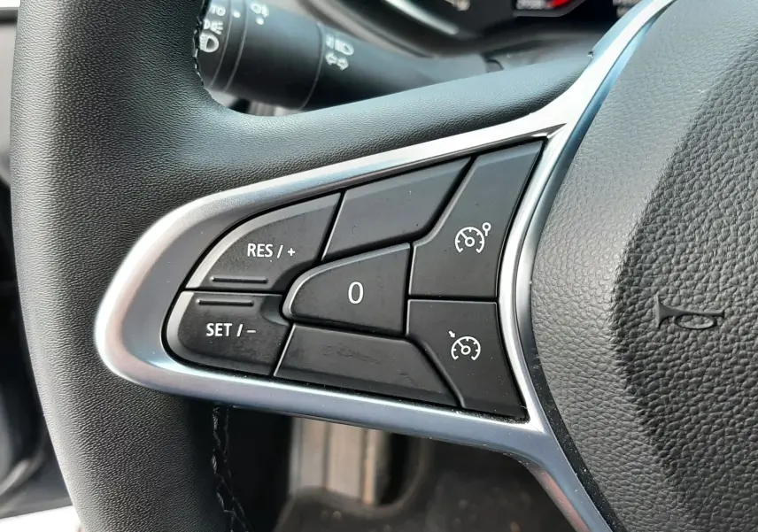 Gros plan sur les commandes de régulateur de vitesse au volant d'une Renault Clio V gris titanium de 2021.