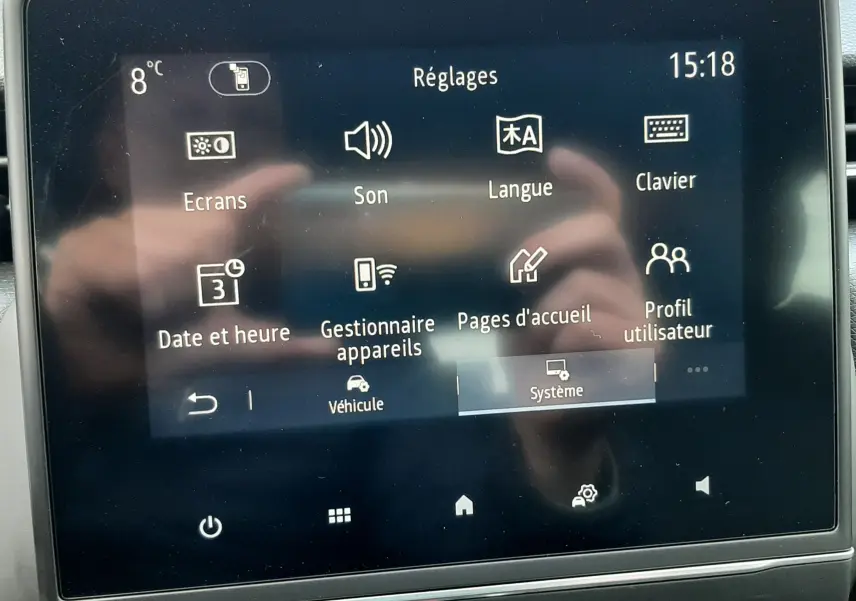 Écran tactile central affichant le menu Réglages dans l'habitacle de la Renault Clio V gris titanium, version TCE 90 Intens.