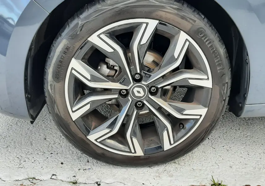 Gros plan sur la roue avant gauche gris titanium d'une Renault Clio V TCE 90 Intens X-Tronic avec jante alliage bicolore.