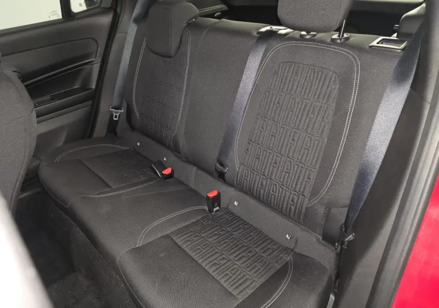 Banquette arrière en tissu noir avec monogramme FIAT, vue côté droit de l'habitacle rouge du FIAT 600 Hybrid 2024.