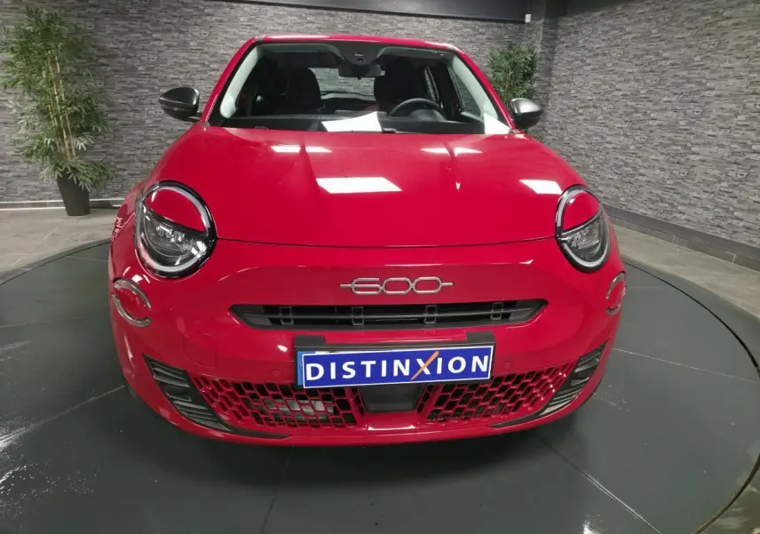 Vue frontale d'une FIAT 600 rouge avec phares ronds et logo 600 au centre du capot