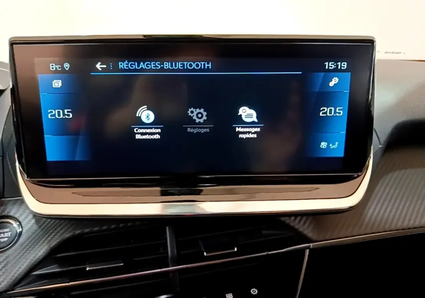 Écran tactile central du tableau de bord du Peugeot 2008 orange, affichant les réglages Bluetooth et la température à 20,5°C.