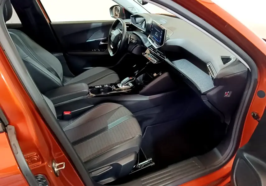 Intérieur avant droit du Peugeot 2008 orange 2021, avec tableau de bord numérique et écran tactile central.