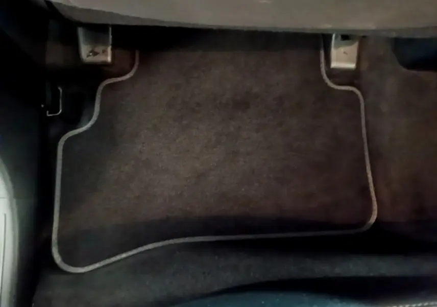 Vue rapprochée du tapis de sol noir côté conducteur du Hyundai Tucson bleu 2023 hybride rechargeable.