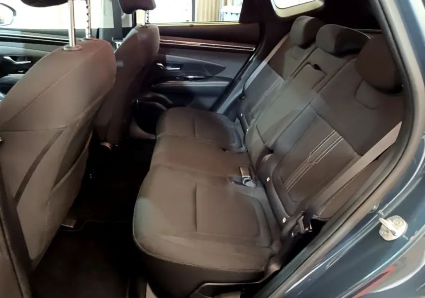 Vue intérieure côté droit des sièges arrière noirs du Hyundai Tucson 2023 bleu hybride rechargeable.