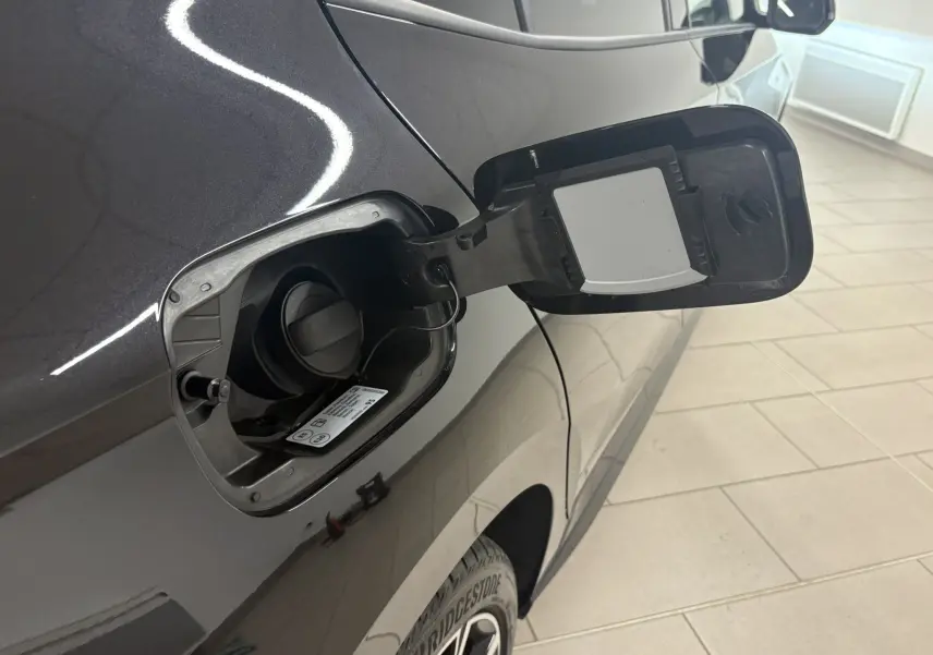 Gros plan sur l'ouverture de la trappe à carburant côté gauche d'une Skoda Fabia 2025 noire nacrée, avec bouchon essence visible.