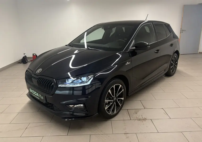 Skoda Fabia Monte Carlo 2025 noir nacré vue 3/4 avant droit en intérieur avec jantes noires et logo distinctif.