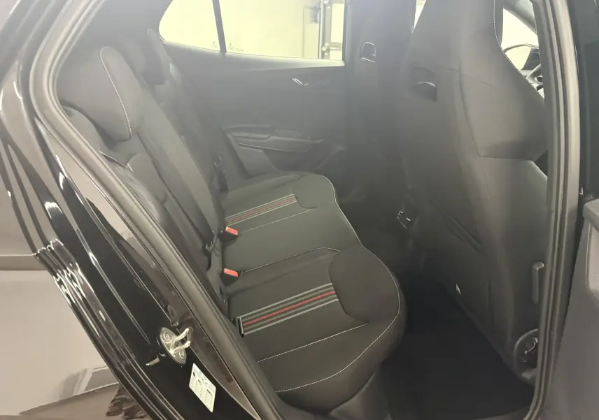 Vue intérieure côté gauche des sièges arrière noirs avec surpiqûres blanches et bandes rouges d'une Skoda Fabia 2025 Monte Carlo.