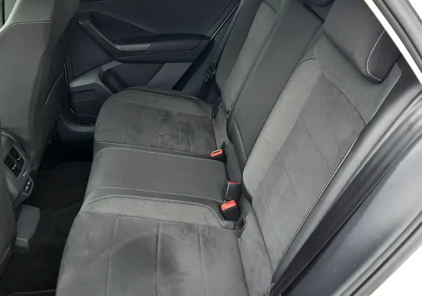 Vue intérieure côté droit des sièges arrière en tissu noir du Volkswagen T-Roc 2022, avec ceinture de sécurité rouge visible.