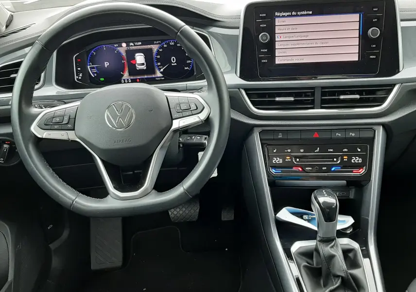Vue intérieure du tableau de bord du Volkswagen T-Roc 2.0 TDI 150ch Style 2022, avec volant multifonction et écran tactile central.