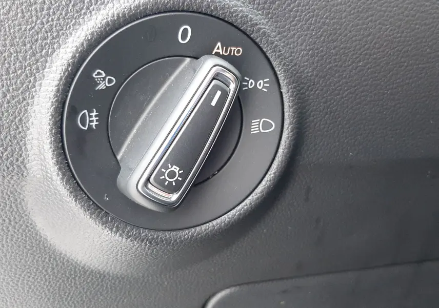 Gros plan sur la molette de commande des phares du Volkswagen T-Roc 2.0 TDI 150ch Style, intérieur noir.