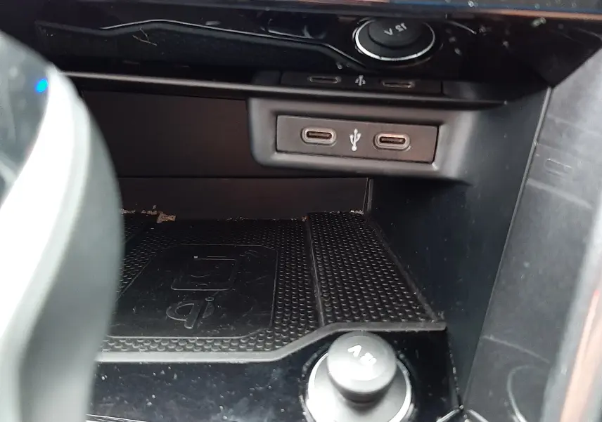 Gros plan sur la console centrale du Volkswagen T-Roc 2022, montrant les ports USB-C et un chargeur 12V.