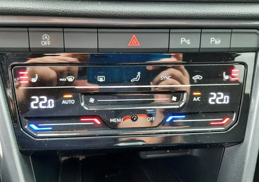 Panneau de contrôle de la climatisation digitale du Volkswagen T-Roc 2.0 TDI, affichant 22°C en mode automatique.