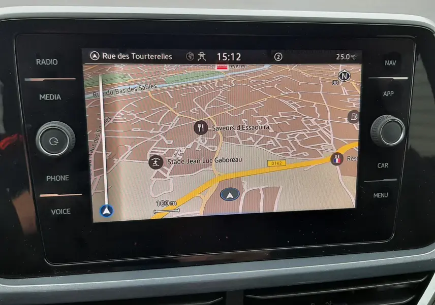 Vue intérieure du système de navigation du Volkswagen T-Roc blanc toit noir, écran tactile affichant une carte détaillée.