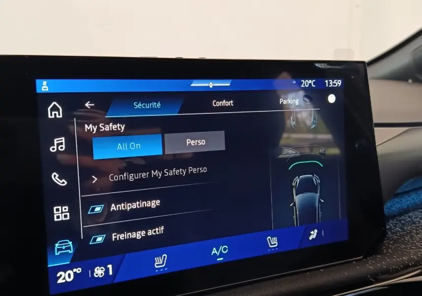 Écran tactile central de la Renault Clio Techno gris foncé, affichant les réglages de sécurité et confort.
