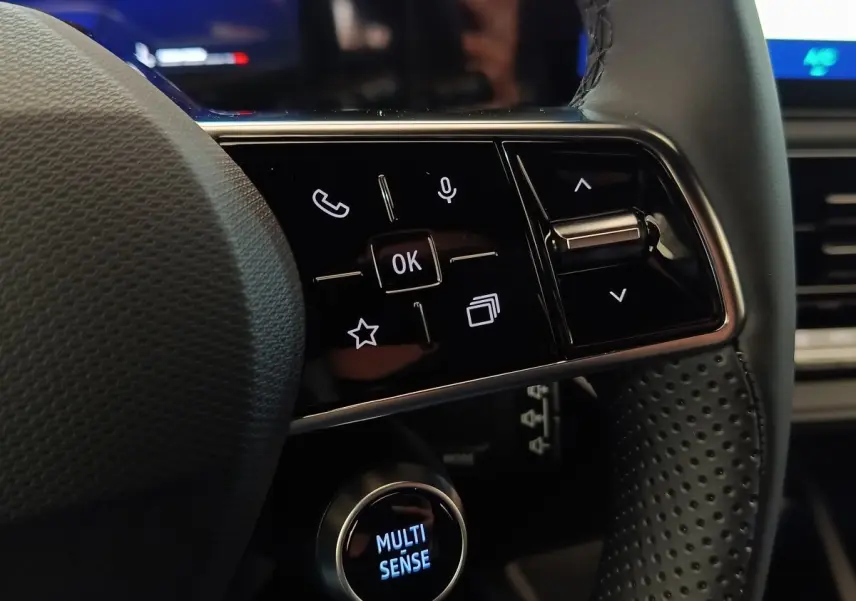 Gros plan sur les commandes multifonctions du volant perforé de la Renault Clio Techno gris foncé 2026.