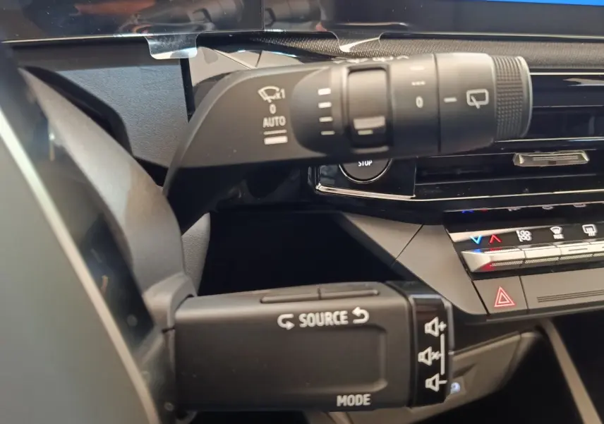 Gros plan sur les commandes au volant de la Renault Clio Techno gris foncé, montrant les boutons multifonctions et le tableau de bord.