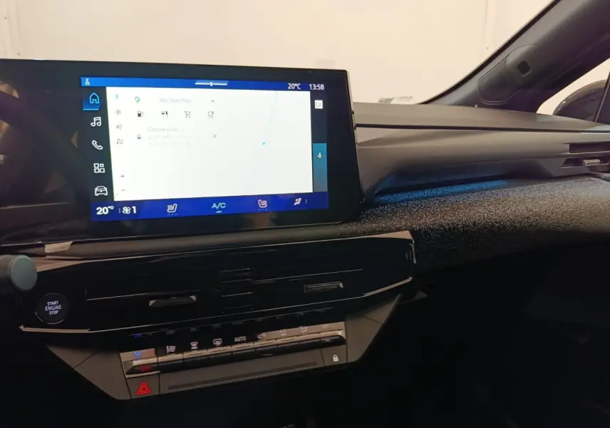 Tableau de bord de Renault Clio Techno gris foncé, vue intérieure centrée sur l’écran tactile et commandes climatisation.
