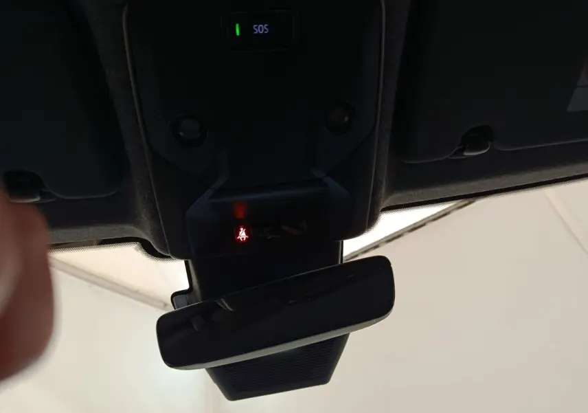 Vue intérieure du rétroviseur central et du plafonnier avec bouton SOS et indicateur de ceinture allumé, Renault Clio gris foncé.