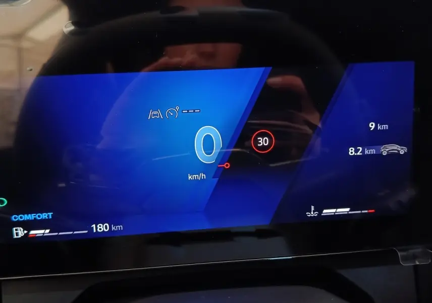 Affichage numérique du combiné d'instruments de la Renault Clio 2026, vue frontale sur écran bleu avec vitesse et alertes.
