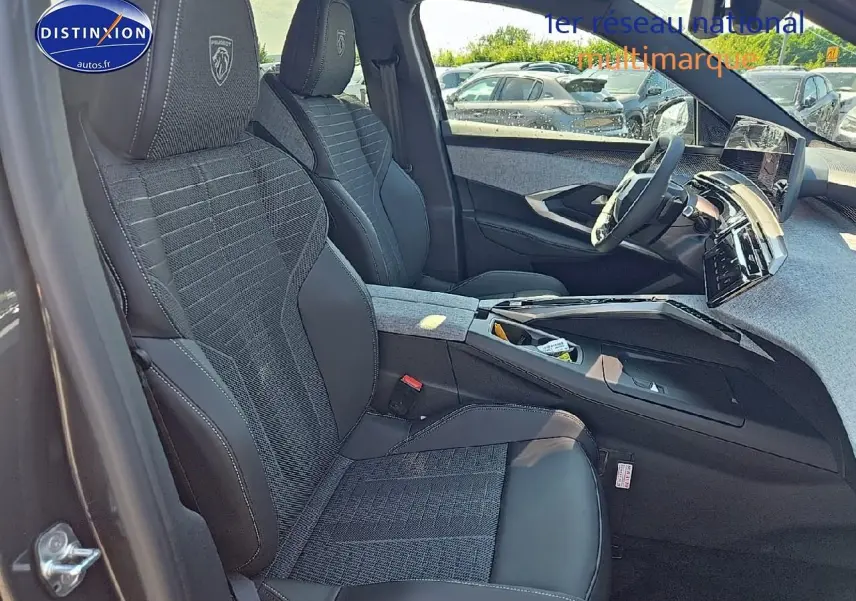 Intérieur avant du Peugeot 5008 Hybrid gris titane, sièges sport avec logo Peugeot et tableau de bord moderne.