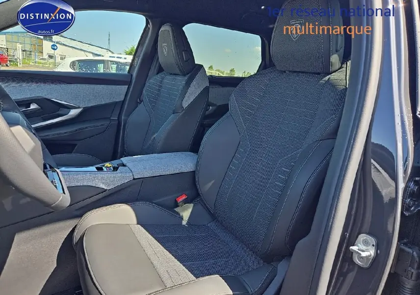 Intérieur du Peugeot 5008 Hybrid 145 GT e-dcs6 vu côté conducteur, sièges tissu et cuir gris avec logo Peugeot brodé.