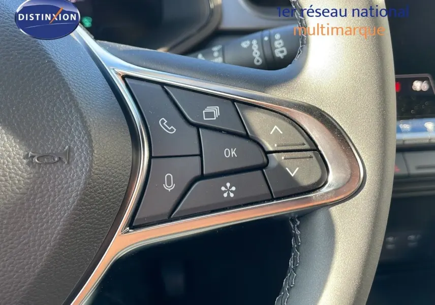 Gros plan sur les commandes multifonctions au volant du Renault Captur E-Tech hybride gris rafale avec finition noire.