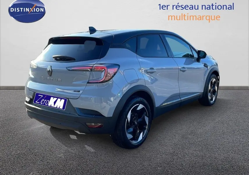 Renault Captur E-Tech hybride gris Rafale 3/4 arrière côté gauche avec toit noir et jantes bicolores.