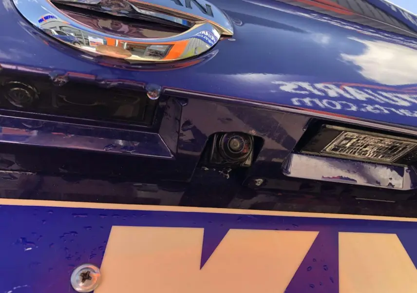 Gros plan sur la caméra de recul intégrée au hayon bleu métallisé du Nissan Qashqai 2019.