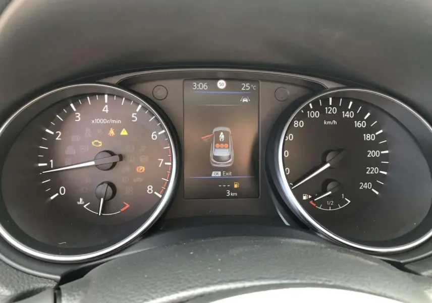 Vue rapprochée du tableau de bord du Nissan Qashqai bleu, affichant compte-tours, vitesse et écran central numérique.