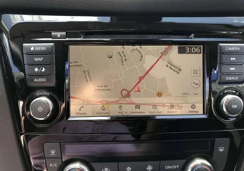 Écran tactile central du Nissan Qashqai bleu 2019 montrant la navigation GPS avec commandes autour.