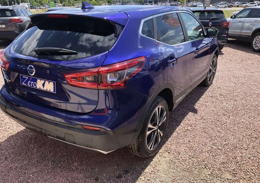 Vue 3/4 arrière droite d'un Nissan Qashqai bleu métallisé avec jantes alliage et feux arrière LED distinctifs.