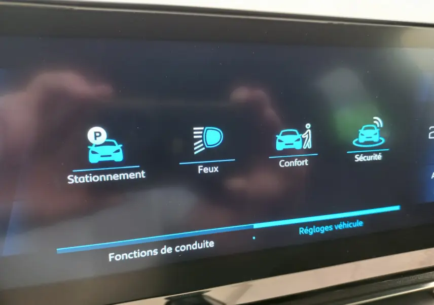 Écran tactile intérieur du Peugeot 5008 gris foncé, affichant les options de conduite et sécurité.
