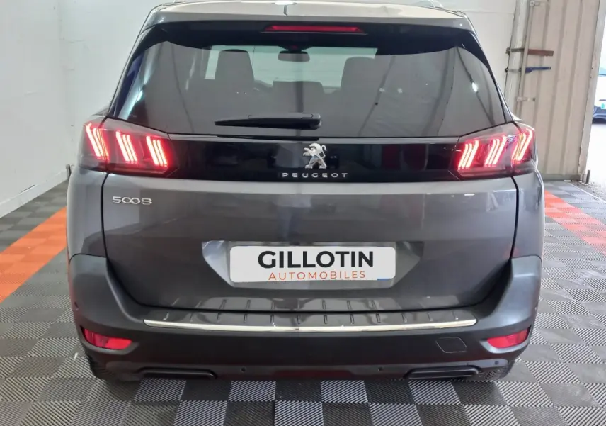 Vue arrière d’un Peugeot 5008 gris foncé avec feux LED caractéristiques et logo lion au centre du hayon.