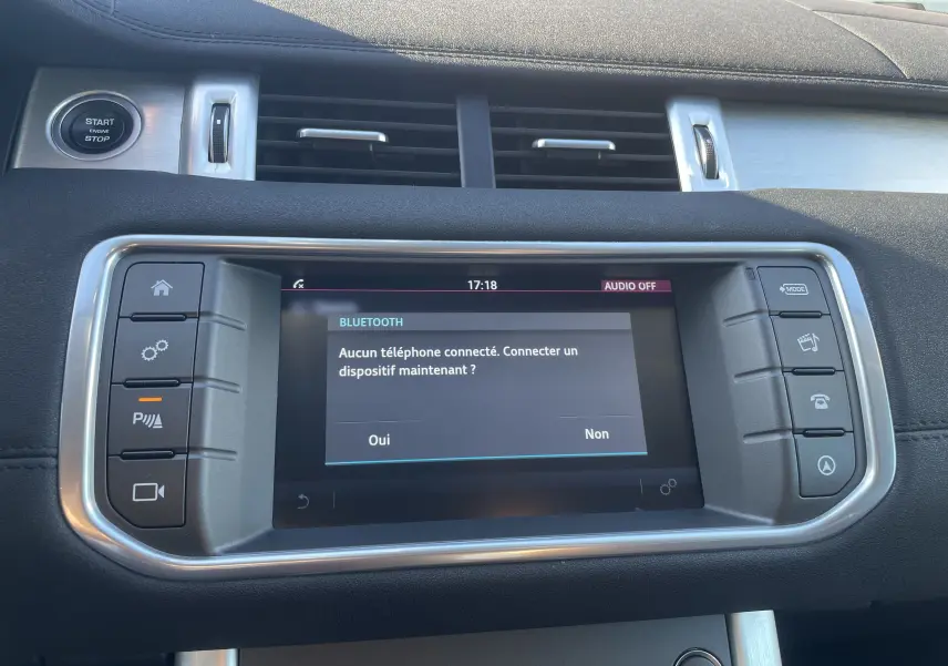 Vue rapprochée de l'écran tactile central et des commandes du tableau de bord du Range Rover Evoque noir, version 2016.