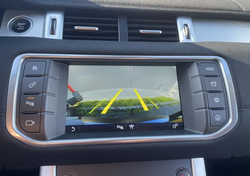 Écran central du Range Rover Evoque noir 2016 montrant la caméra de recul avec lignes de guidage jaunes.