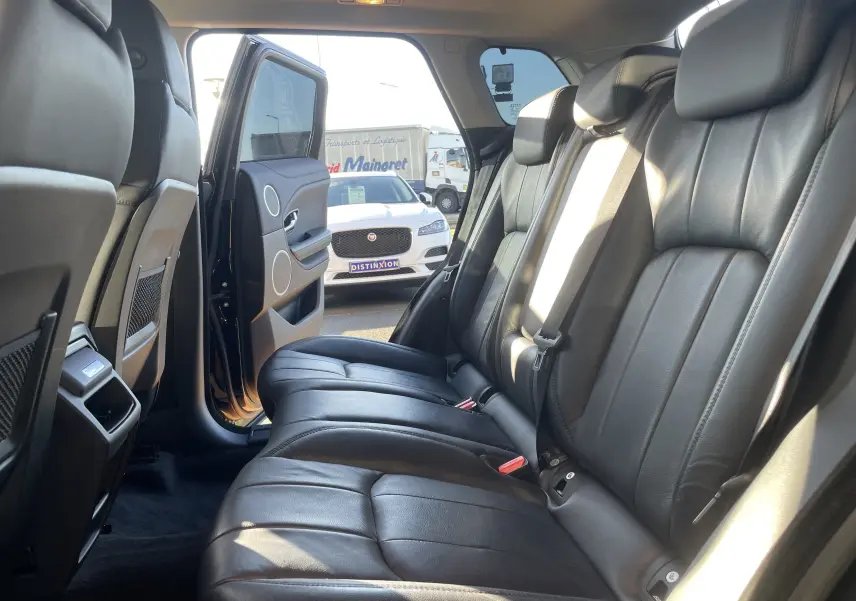 Vue intérieure côté droit des sièges arrière en cuir noir du Range Rover Evoque 2016 avec porte arrière ouverte.