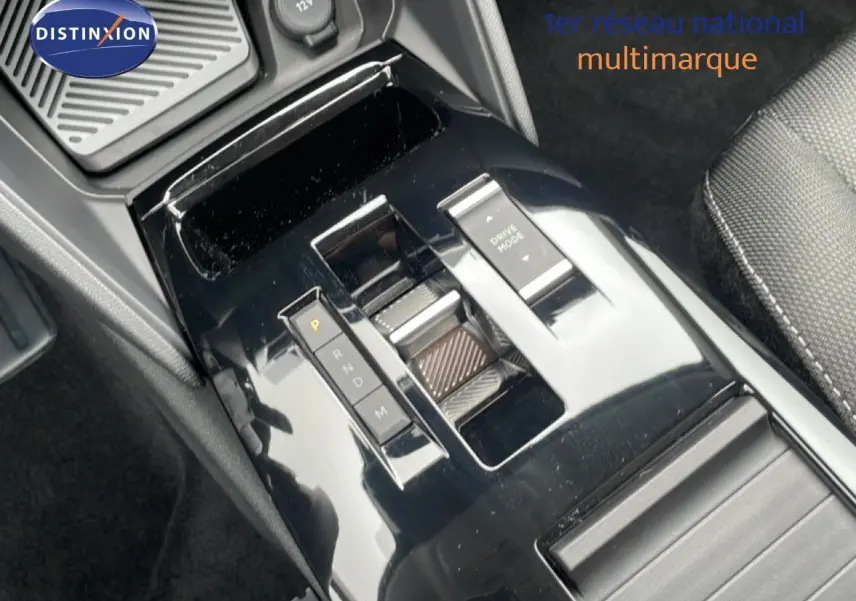 Gros plan sur la console centrale noire brillante de la Citroën C4 blanche, avec levier de vitesses automatique et bouton Drive Mode.