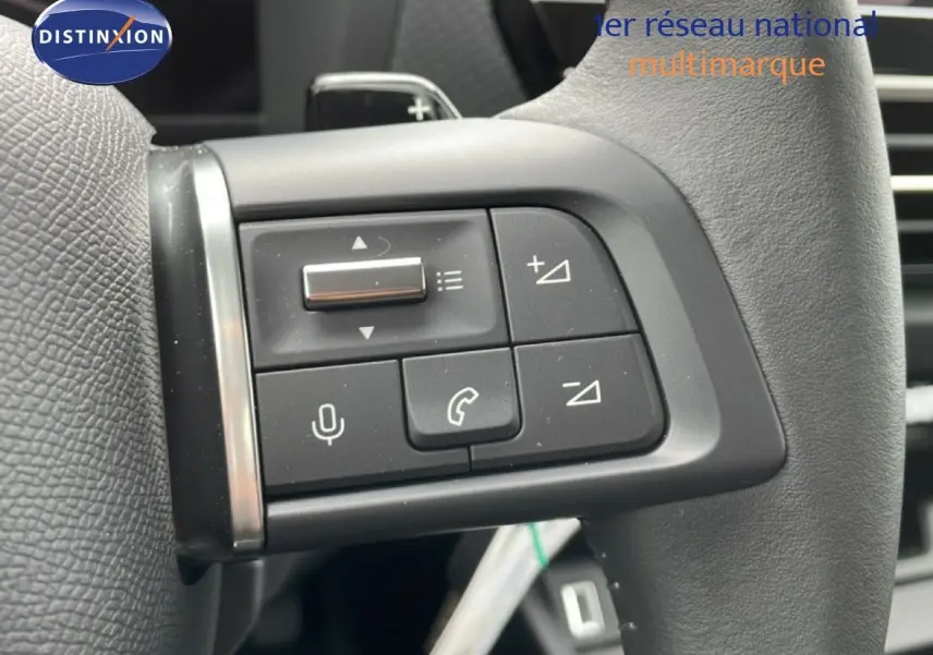 Gros plan sur les commandes au volant en cuir noir du Citroën C4 blanc métal, version PureTech 130ch EAT8 Plus.