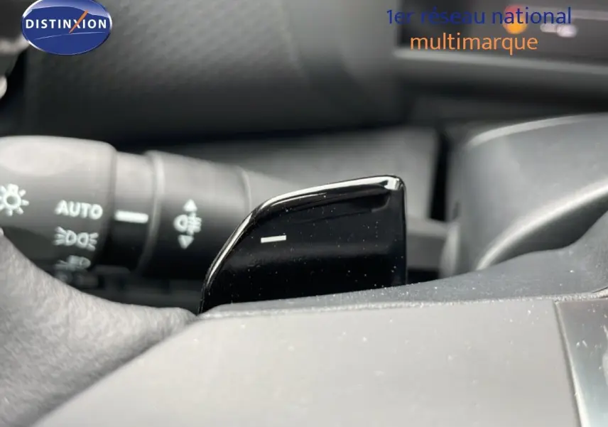 Gros plan sur la palette de changement de vitesse noire côté droit du volant d'une Citroën C4 blanche.