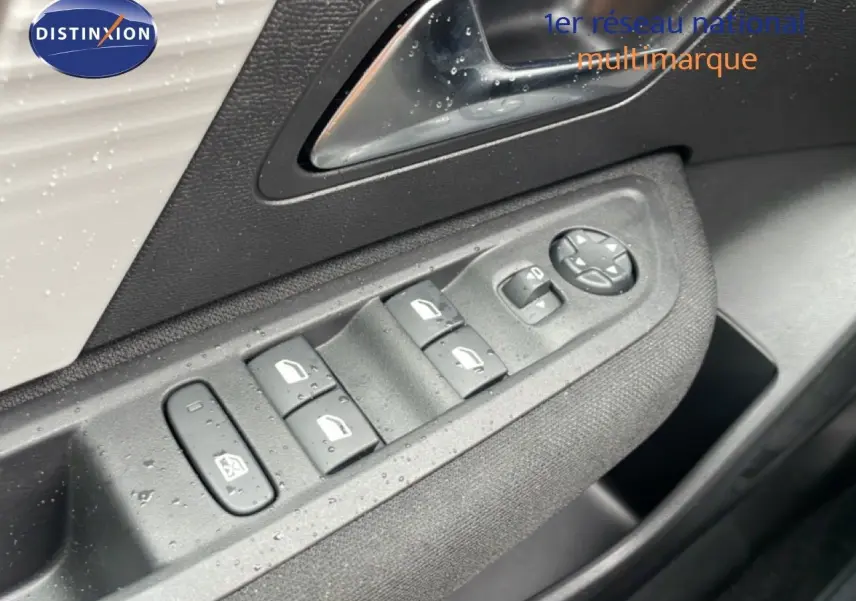 Gros plan sur les commandes des vitres et rétroviseurs côté gauche d’une Citroën C4 blanc métal.