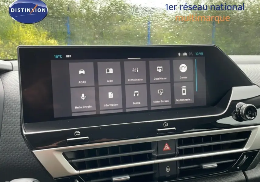 Vue rapprochée de l’écran tactile central et de la console d’une Citroën C4 blanche, affichant les options multimédia et climatisation.