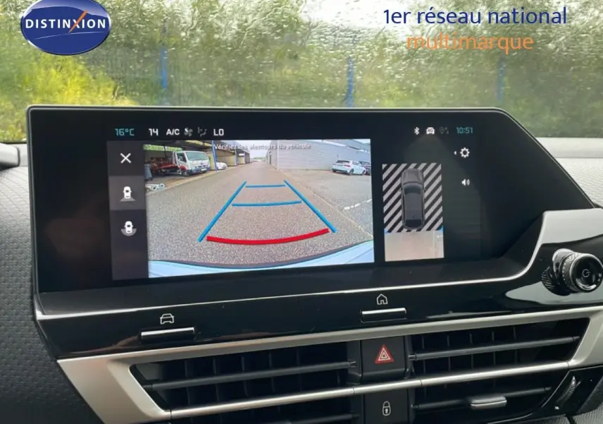 Vue intérieure du tableau de bord de la Citroën C4 blanc métal, affichant la caméra de recul sur l'écran tactile.