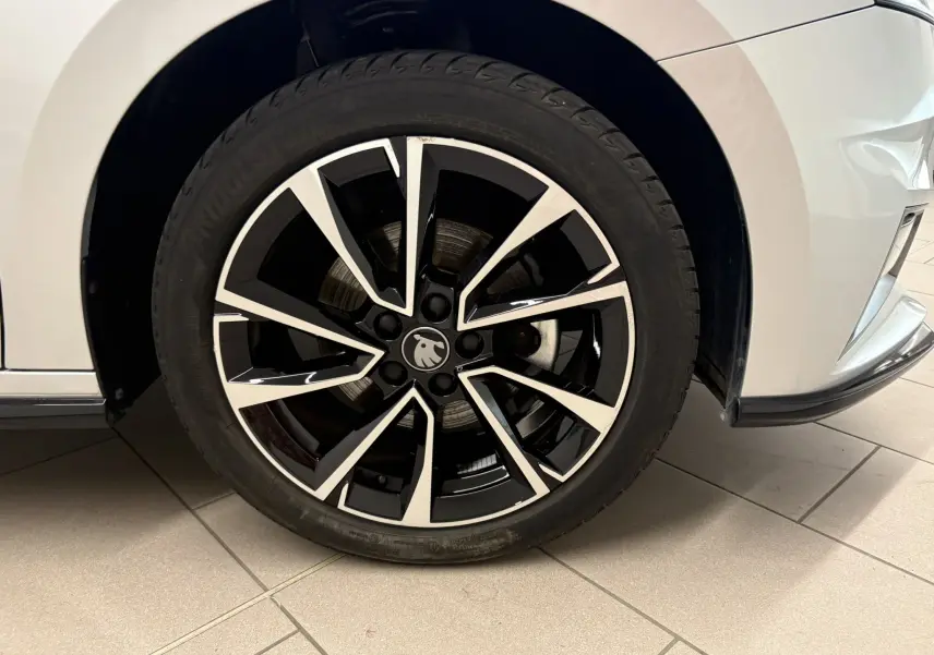 Gros plan sur la roue avant droite d’une Skoda Fabia 2025 gris argent, jante alliage noire et argentée design Monte Carlo.