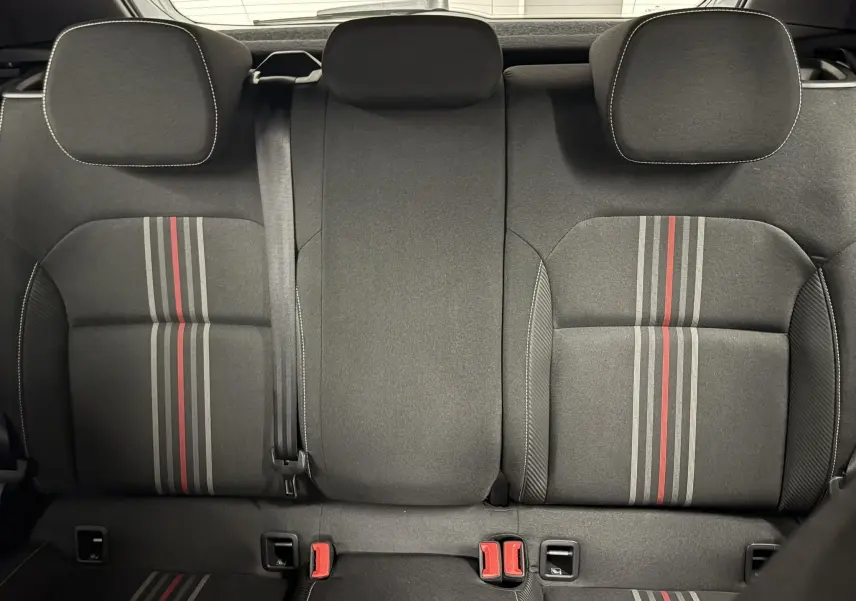 Vue arrière intérieure des sièges arrière de la Skoda Fabia Monte Carlo 2025, tissu noir avec bandes grises et rouges.