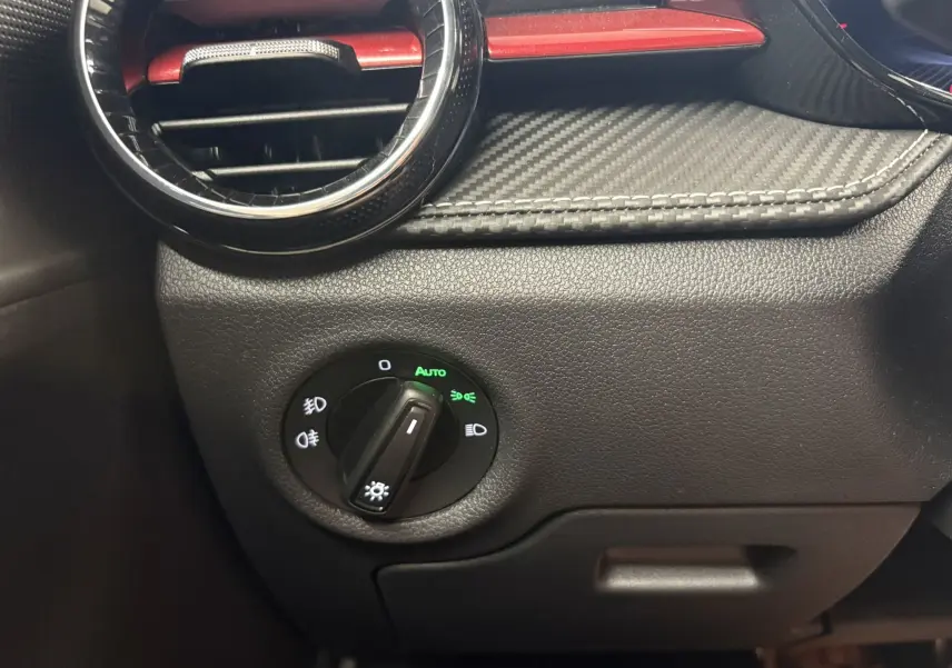 Détail du tableau de bord côté gauche d’une Skoda Fabia 2025, avec commande d’éclairage et insert carbone rouge.